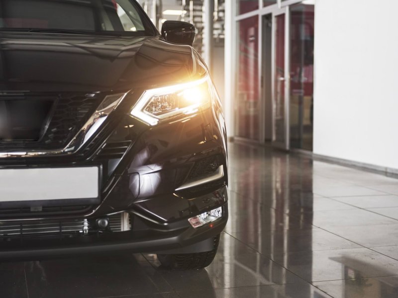 The headlights and the hood of a black luxury car