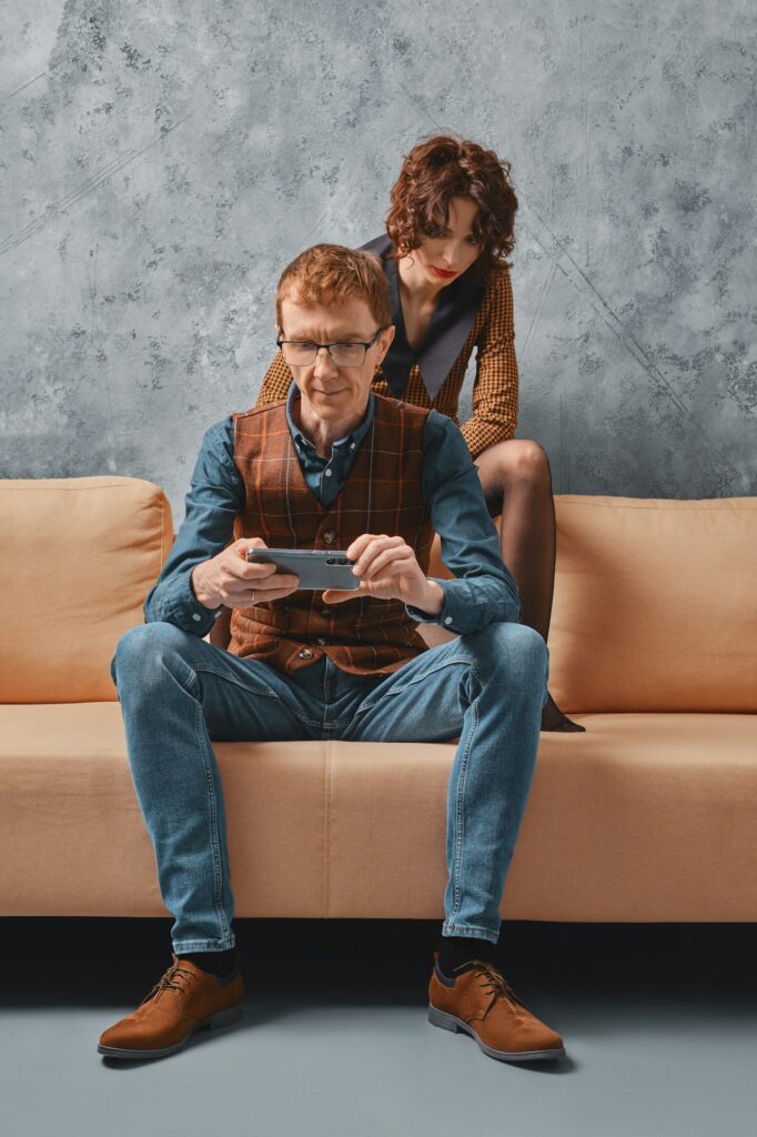 Middle aged man adjusts control of smart home on smartphone