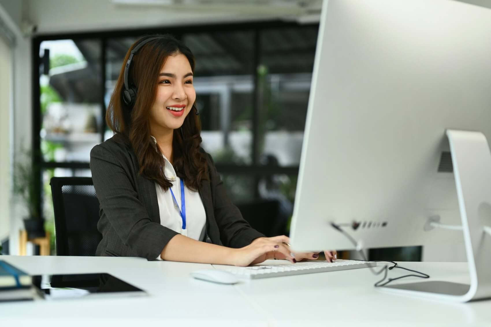 Customer service representatives wearing headset working on support hotline in modern workplace