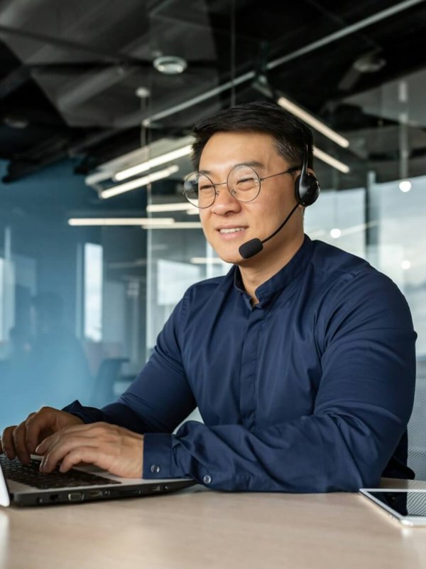 Happy and smiling worker with headset for video call, Asian tech support man talking to online